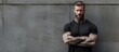© Ilgun - A tough looking man with a tattoo standing against a gray brick wall Copy space image