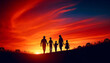 Silhouette of a family walking hand in hand against a vibrant sunset sky. The family consists of two adults and three children