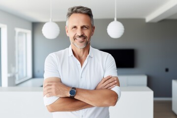 Wall Mural - Portrait of a grinning man in his 50s with arms crossed isolated in modern minimalist interior