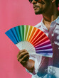 Stylish Designer with Color Swatch Fan Against Pink Background.