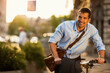 © Geber86 - Smiling young businessman riding a bicycle in city
