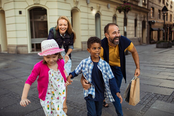 Wall Mural - Joyful diverse family having fun on a city walk