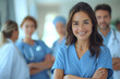 © gearstd - Young nurse with medical team in soft focus