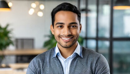 Wall Mural - attractive smiling male office worker posing in office and looking at camera