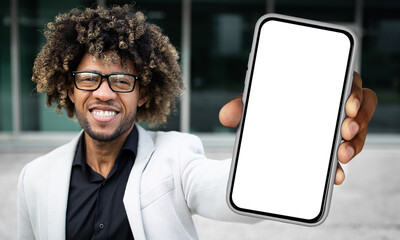 Poster - Black man standing and holding a smartphone in front of him, displaying a blank white screen. The mans hand is clearly visible as he holds the device upright.