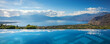 Infinity pool overlooking the green mountain landscape and the sea