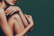 © Alienmonster Images - Nude woman embracing herself against dark green background with flawless skin