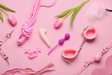 Wall Mural - Composition with different sex toys and tulip flowers on pink background