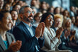 © ArtCraft - Joyful audience engagement at a seminar. The image captures a diverse group of people clapping, portraying enthusiasm and participation, ideal for use in event promotion and professional development.
