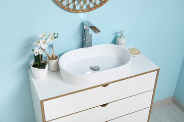 Poster - Modern sink with bath supplies on countertop near blue wall in bathroom