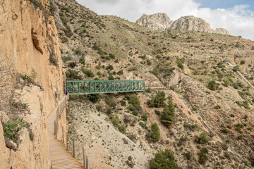 Wall Mural - green railway train track bridge and tunnel. Hiking trail caminito del rey, kings walkway, El Chorro Spain. narrow footpath leads through natural beauty mountain range cliff faces of gaitanes gorge. 