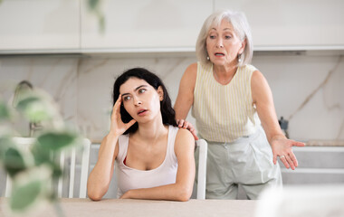 Wall Mural - Elderly woman during family quarrel with young woman in kitchen at home