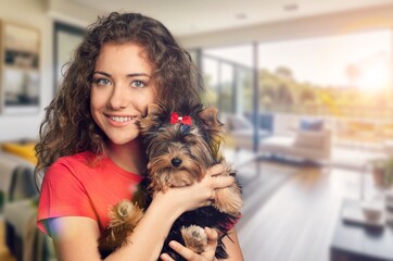 Canvas Print - a girl holds cute domestic dog in room background