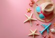 Flat lay of summer accessories on a pastel pink background, starfish, hat, sunglasses, toy airplane

