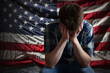 © Pinon Road - Upset Young Man Sitting in Front of American Flag with his Head in Hands - Political Anxiety Concept