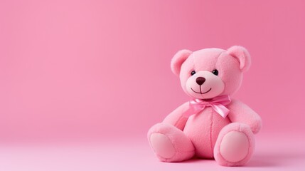 toy plush pink bear with a silk bow on pink background with copy space