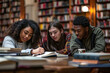 © fahrwasser - Three focused diverse students collaborate on their studies in a well-lit library
