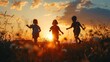 Silhouette of three happy children which playing on the field at the sunset time. They having fun on the nature.