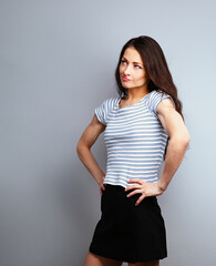 Wall Mural - Fun suspicious grimacing casual woman thinking and looking up on blue studio background on empty copy space. Closeup