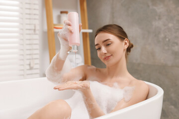 Sticker - Woman pouring shower gel onto hand in bath indoors