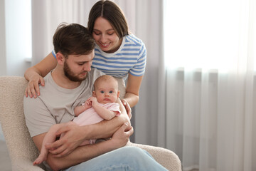 Wall Mural - Happy family. Parents with their cute baby at home, space for text