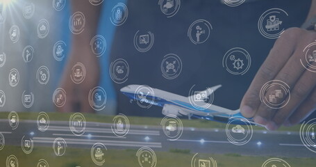 Poster - Image of digital icons over mid section of a woman flying a airplane model at office