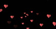 Image of red heart icons floating against copy space on black background