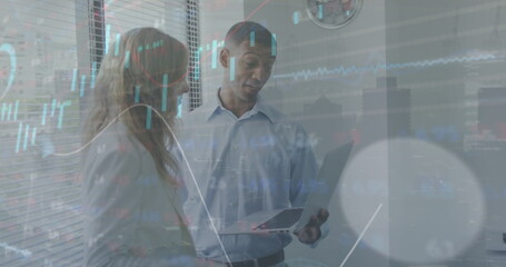 Canvas Print - Image of graphs, loading circles, trading board, diverse coworkers discussing reports on laptop