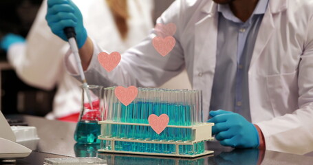 Poster - image of hearts over caucasian male scientist using pipette in lab