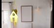 Golden house-shaped keychain hanging in focus, with blurry background