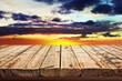 Wooden table on sky background and sunset light	
