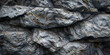 A black and grey rock background with a black pattern .
