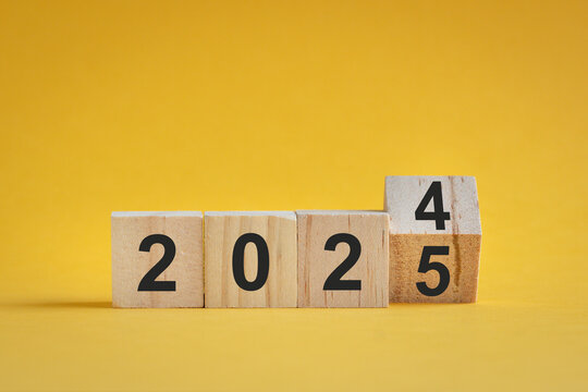 From 2024 to 2025, numbers on wood blocks. On yellow background, new year concept