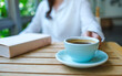 © Farknot Architect - Closeup image of a woman holding and drinking coffee with a book on table