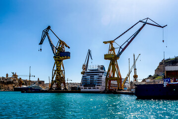 Huge Ship yard cranes in Malta. Valletta has a deep sea port for shipping and massive dry docks for ship yard works.