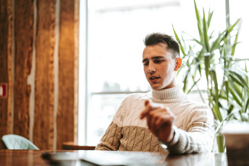 Poster - Man Sitting at Table With Laptop Computer