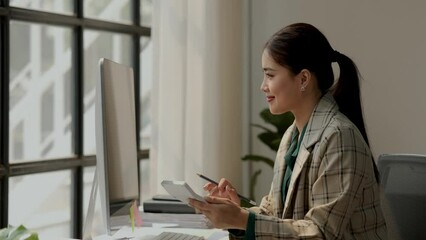 Wall Mural - a female accountant is using calculator, head of marketing department is planning to analysis about investment in currency, calculating to pay yearly tax, find the total of the company's expenses