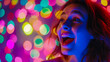 © VISUAL BACKGROUND - A woman laughing in front of colorful lights.