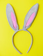 Grey rabbit ears for Easter on a yellow background