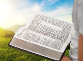 Canvas Print - Open bible in human hands outdoor