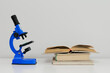 Blue microscope and books on table