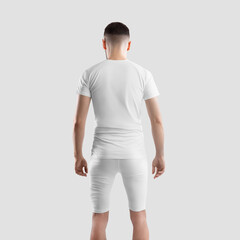 Wall Mural - Mockup of white sports t-shirt on athletic guy, back view, male compression suit, shirt, shorts for design, branding, advertising.