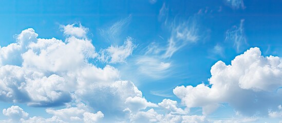 Poster - The serene light blue sky is adorned with fluffy clouds creating a picturesque natural backdrop There is ample copy space in the image