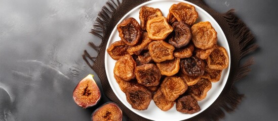 Poster - Top view of a plate of dried figs on a grey background with ample space for text creating a copy space image The figs exude healthiness and nutrition