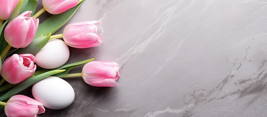Poster - A copy space image featuring pink tulips and Easter eggs arranged on a stone surface