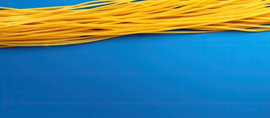 Aufkleber - A yellow strand of long spaghetti is placed on a blue background with ample copy space available for additional elements or text
