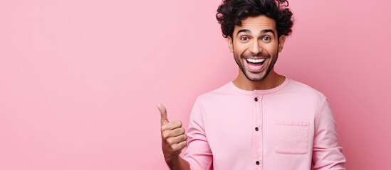 Aufkleber - Excited young Hispanic man with a happy smile stands over a pink background pointing with open palms towards copy space ready to present an advertisement