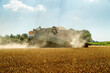 Agricultural machine harvesting golden wheat in a sunny field