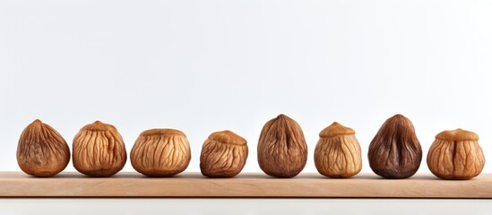 Poster - A minimal composition of whole dried figs in a row isolated on a light background providing copy space for additional content