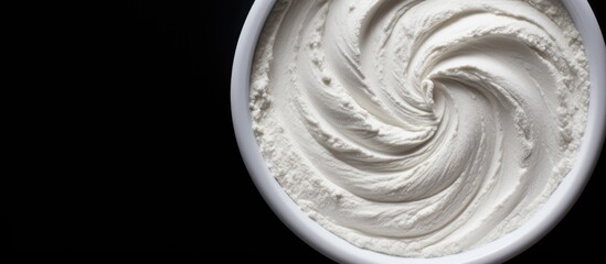 Poster - A top down view of white cosmetic clay on a black background with copy space for text or images